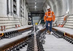 Construction worker inspecting quality of newly laid track