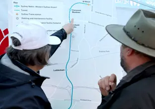 Woman pointing to station on the Western Sydney Airport project alignment map