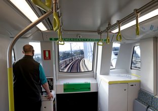 Worker standing at the front of a metro train testing train speed.