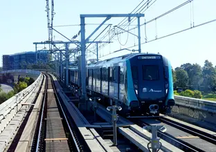 Wide shot of metro train travelling along metro line.