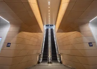 Long vertical shot of escalators and wall panelling in the underground pedestrian concourse at Central Station.