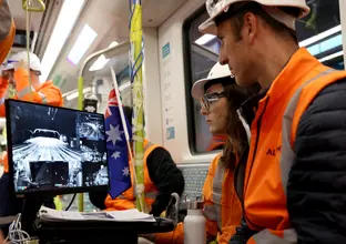 Two engineers watch a computer screen on a metro train as testing commences for CIty & Southwest.