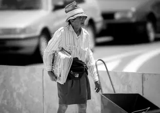 Beatrice Bush standing with a pile of newspapers to sell 