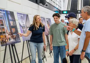 Lady pointing at a sign showing a group of people