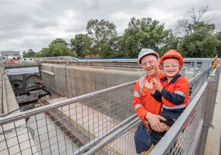 Man holding young boy above the tunnels