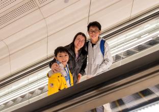 Mother and two children going up the escalator
