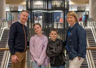 Family in front of the lifts and escalators on the platform