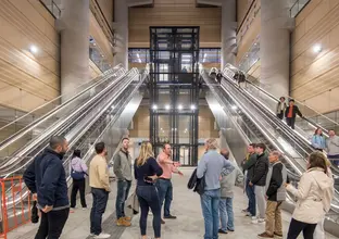 Group of people at the community open day in front of the escalators and lift