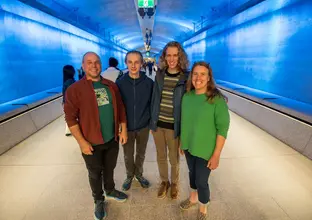 Family of four standing in the blue lit up tunnel