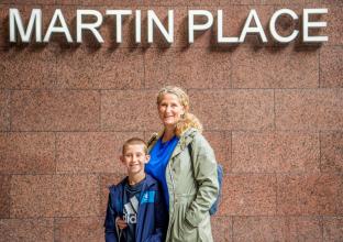 Mother and Son in front of Martin Place sign outside the station