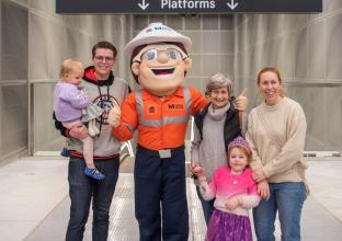 Family surrounded by the Sydney Metro Mascot