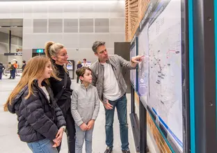 Family looking at the Sydney Metro map with Dad pointing out something