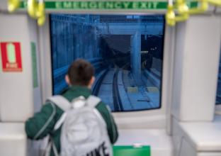 a young boy looking at the tracks from the newly opened city line metro 