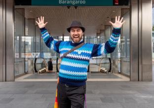 A man posing happily for the camera with hands up in the air at the City and Southwest Opening