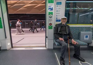 an elderly passenger sitting at the newly opened city line metro