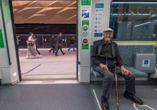 an elderly passenger sitting at the newly opened city line metro