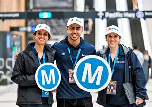 Metro employees holding two M logos