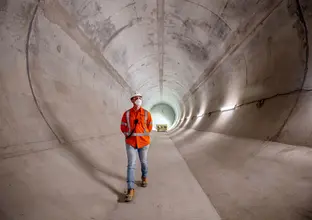 A worker walking through a completed tunnel of WSA project