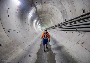 A worker walking through a completed tunnel of WSA project