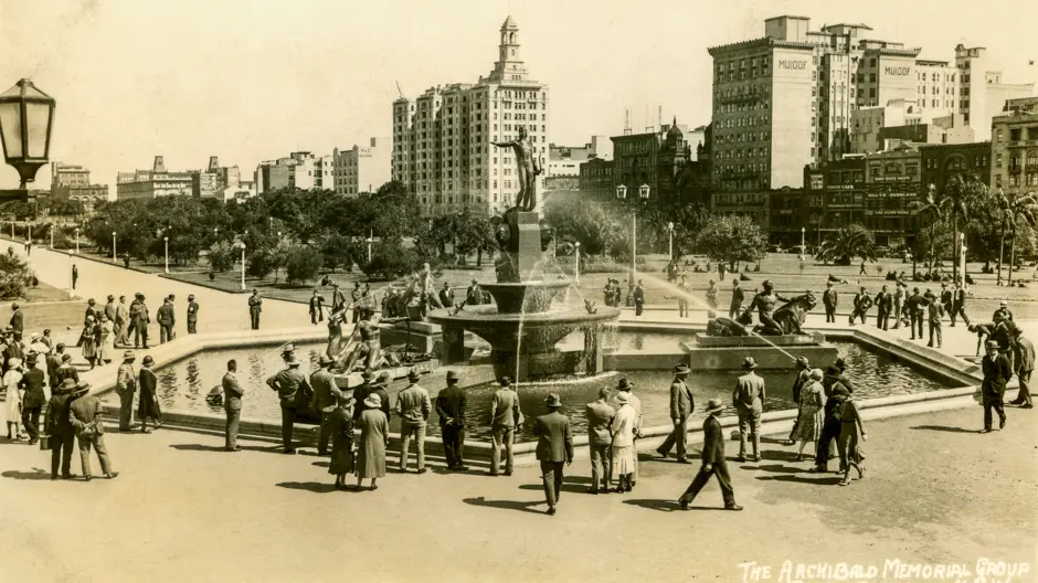 Sepia coloured photo of people gathering at the Archibald Fountain in Hyde Park North, c.1930. 