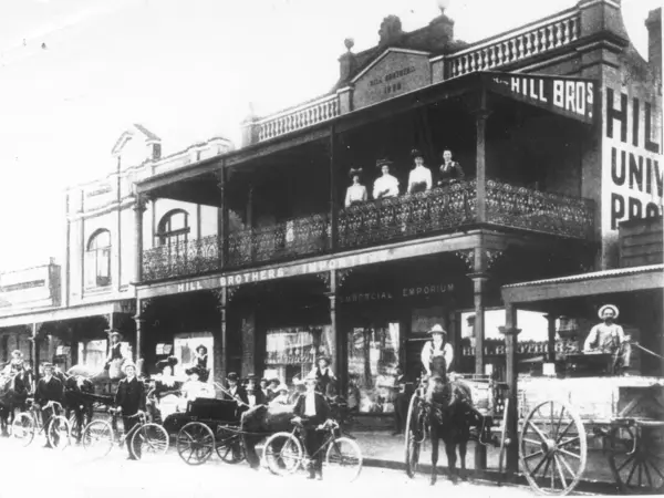 Black and white photo of horse-drawn vehicles and bicycles outside Hill Bros. Importers, Chatswood in 1904