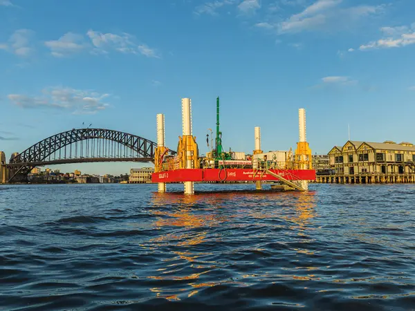 Early works drill barge on the harbour with Sydney Harbour bridge in the background.