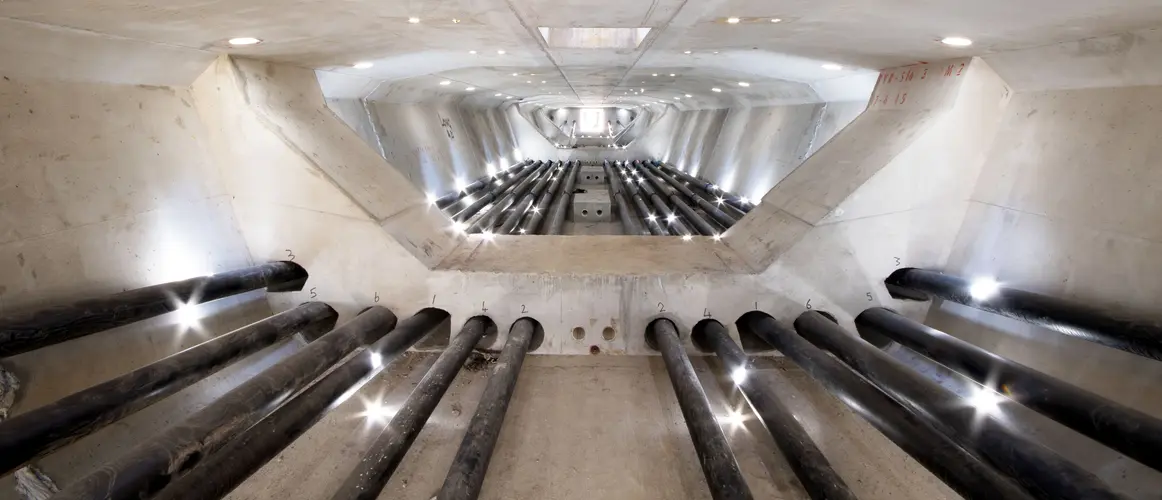 An on the ground view looking inside the tunnel where the skytrain will run showing 12 rows of steel cables running down the tunnel, the skytrain will be held together by 1,400km of steel cables. 