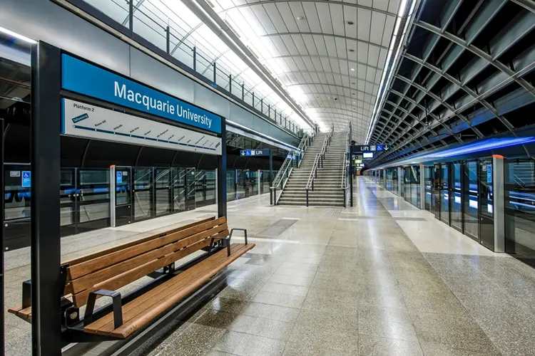 An on the ground shot from the platform behind the screen safety doors showing the platform benches at Sydney Metro's Macquarie University Station.