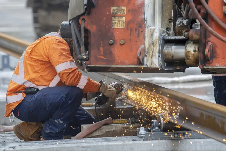 A construction worker in high viz welding train track at Waterloo