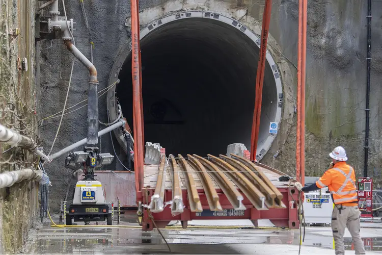 A construction worker moving trail track into the tunnel opening at Waterloo Station