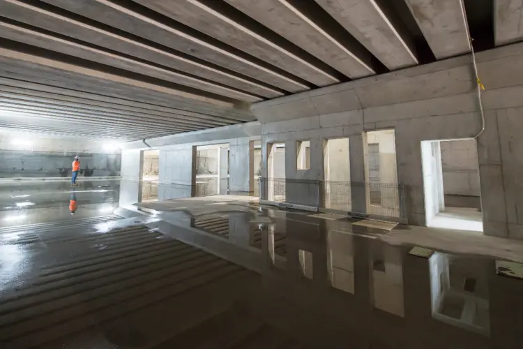 A view inside the cassette structure at Chatswood Dive Site. A puddle of water shows reflections on the ground.