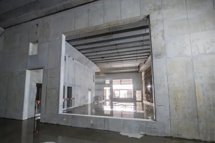 The opening to the cassette structure at Chatswood Dive Site. Puddles of water show reflections on the ground.