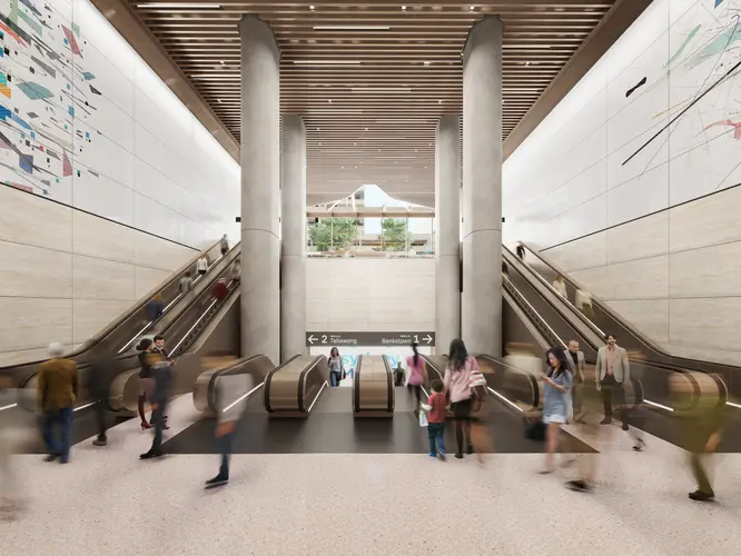 Artist's impression of commuters walking down the Pitt Street North Station Escalators. There are four escalators going down to the platforms in the middle and two escalators on either side that are going up to street level.