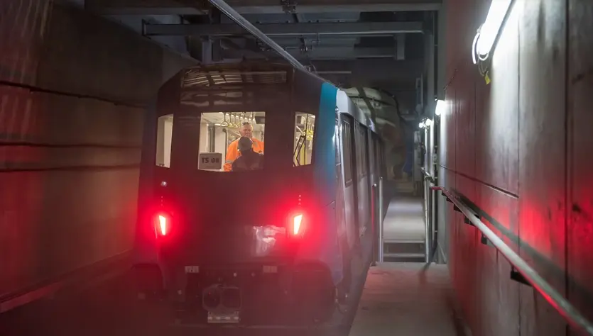 A Sydney Metro train being tested by two Sydney metro employees inside a tunnel. 