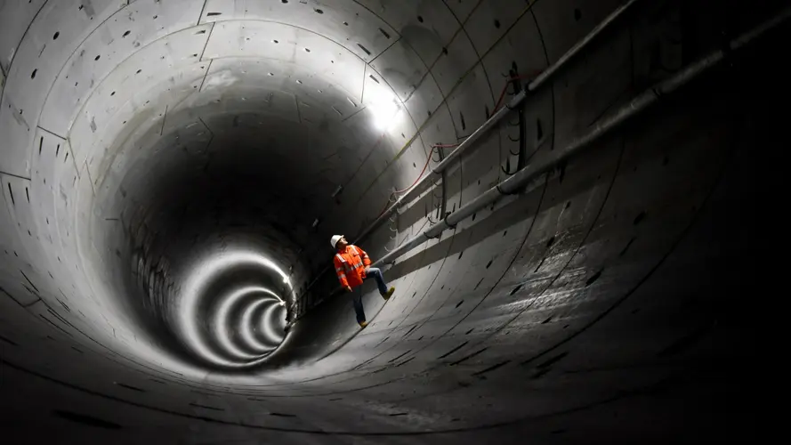 Construction worker standing inside the Hills Showground Station tunnel and Castle Hill crossover cavern