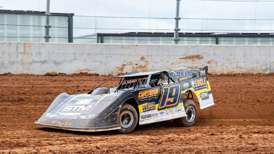 A yellow and black race car drives in the dirt track at the new Eastern Creek Speedway.