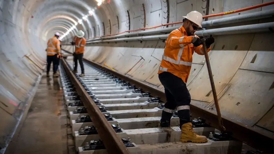 Construction workers putting in concrete railway sleepers onto underground tunnel railway line at Sydney Metro's Blue Point site between Victoria Cross and Barangaroo Station. 