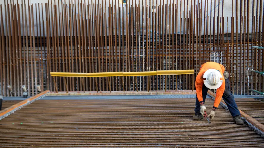 Construction worker installing metal rods at Sydney Metro's Crows Nest Station.