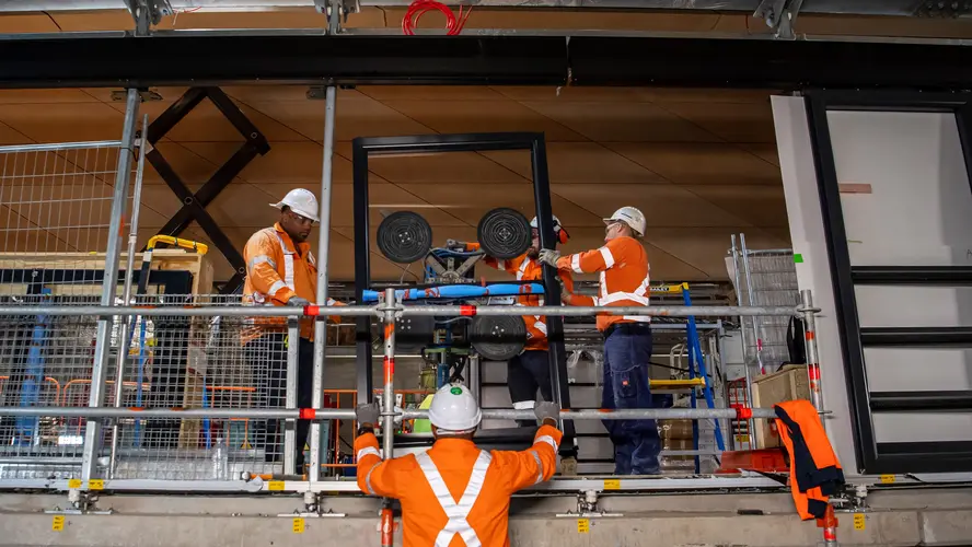 Construction workers installing platform screen doors at Central Station. 