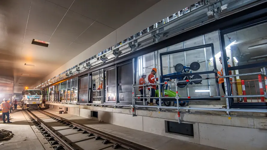 Construction workers installing platform screen doors at Sydney Metro's Waterloo Station