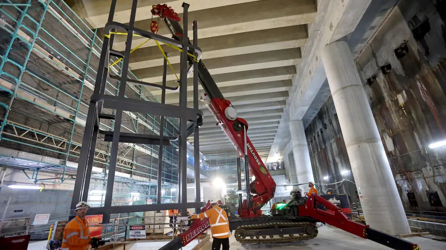 Steel structures are craned into position inside Barangaroo Station's underground cavern