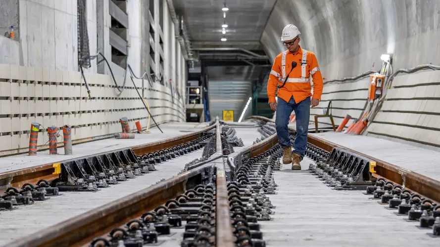 Construction worker inspecting quality of newly laid track