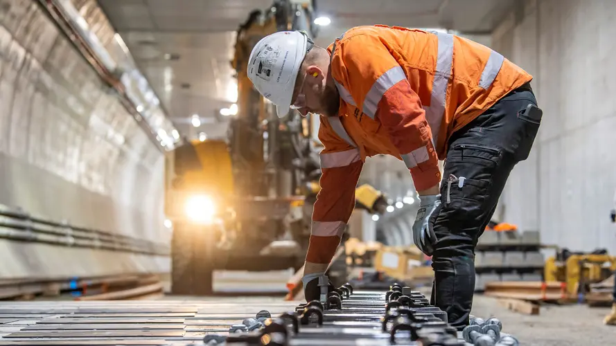 Construction worker laying final rail tracks