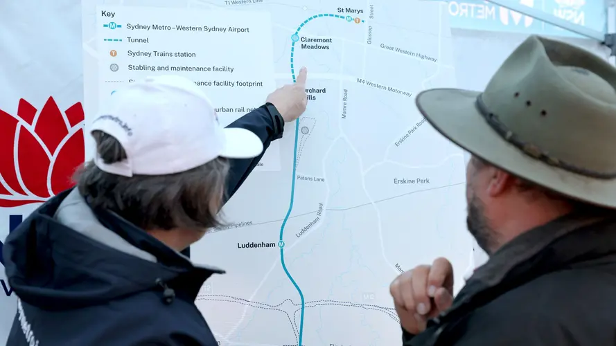 Woman pointing to station on the Western Sydney Airport project alignment map