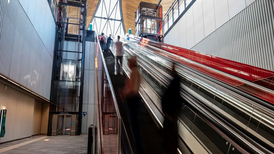 A view from the bottom of people going up the escalators at Castle Hill Station.