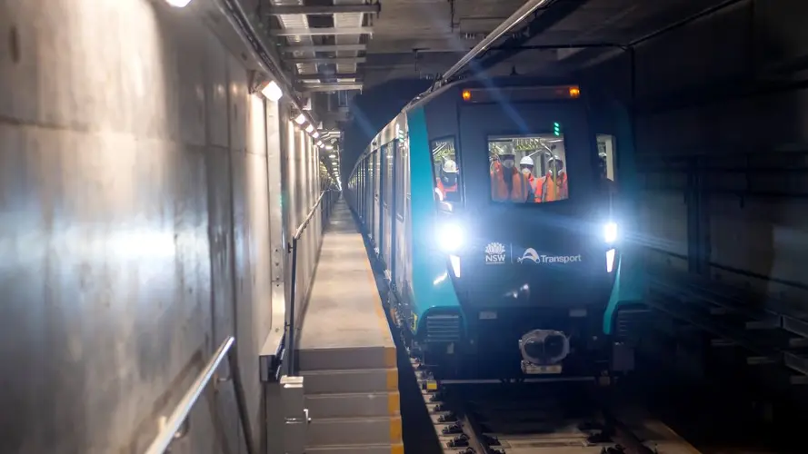 Train testing under a tunnel with workers inside the train wearing safety gears 