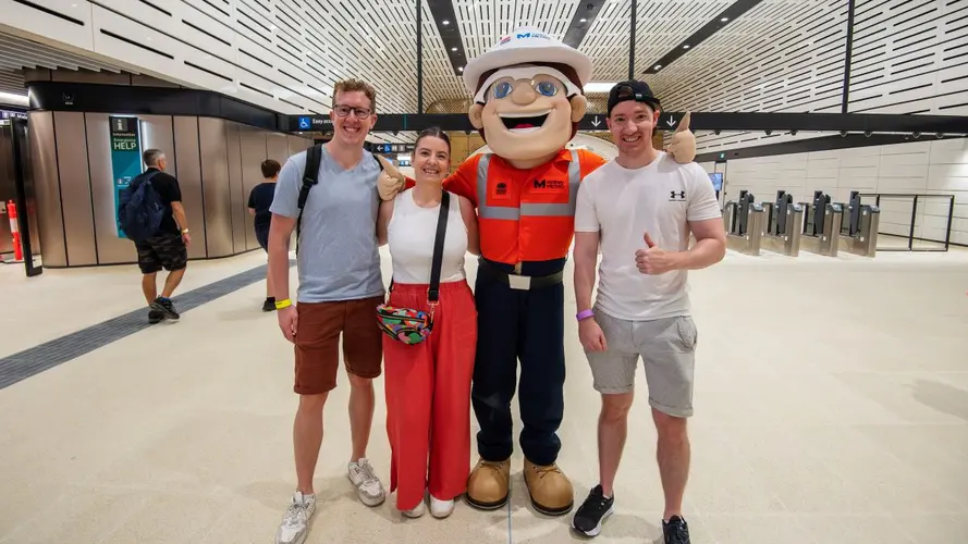 Mascot with three people posing for a photo