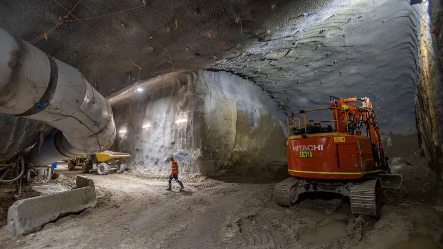 Man in high vis and orange machine in the cavern