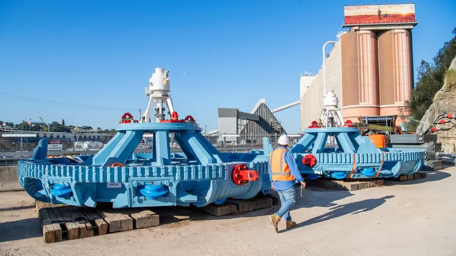 Construction worker walking in front of TBM cutterhead