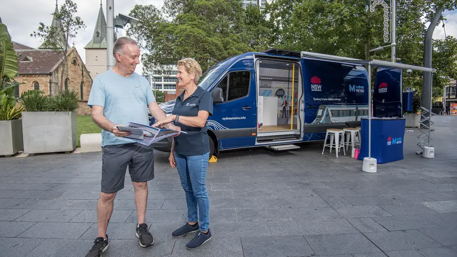 Sydney Metro employee talking to civilian in front of the Sydney Metro van